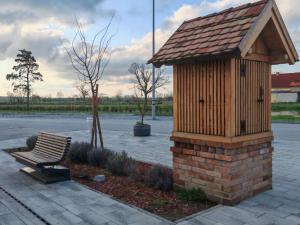 a bird house and a bench in a park at Apartmani Tea i Toni - Apartment Toni in Gradište
