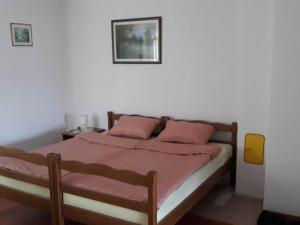 a bedroom with a bed with pink pillows at Apartmani Tea i Toni - Apartment Toni in Gradište