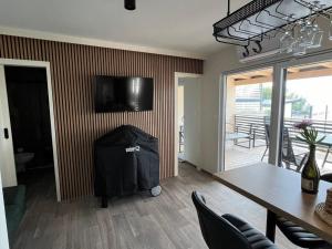 een kamer met een tafel en een televisie aan de muur bij Two Bedroom Mobile Home with Terrace and Sea View in Drage