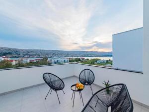 zwei Stühle und ein Tisch auf einem Balkon mit Aussicht in der Unterkunft Luxury Villas Bellavista - Four Bedroom Villa with Pool in Pag