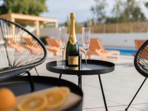 eine Flasche Champagner und zwei Weingläser auf dem Tisch in der Unterkunft Luxury Villas Bellavista - Four Bedroom Villa with Pool in Pag
