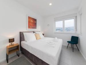 ein Schlafzimmer mit einem Bett und einem Stuhl und einem Fenster in der Unterkunft Luxury Villas Bellavista - Four Bedroom Villa with Pool in Pag + 34 Fotos