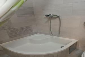 a bathroom with a shower with a white tub at Studio Apartment in Jezerane +13 photos