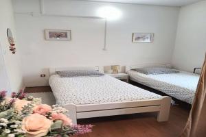 a bedroom with two beds and flowers in it at Studio Apartment in Jezerane