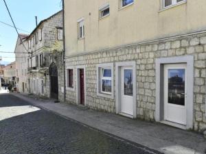 un edificio in mattoni con porte bianche su una strada di Charming Sinj Town Studio Apartments - Studio Apartments a Sinj (Signo)