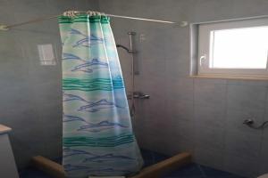 a shower curtain with dolphins on it in a bathroom at Apartments Ana Lopud - Double Room with Balcony and Sea View - 1 floor in Lopud Island