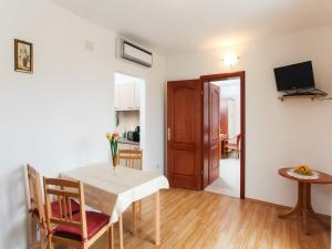 a kitchen and dining room with a table and a television at Apartments Ana Lopud - Double Room with Balcony and Sea View - 1 floor in Lopud Island