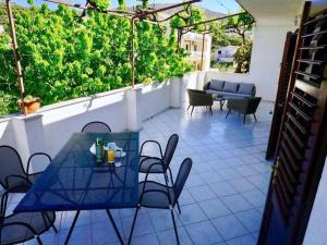 a patio with a blue table and chairs on a balcony at Three Bedroom Apartment with Terrace in Seget Vranjica