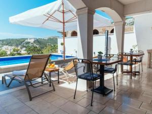 a patio with chairs and a table and an umbrella at Apartments Trogrli - Studio with Balcony in Hvar