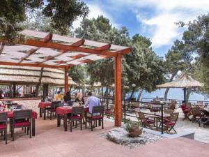 Un restaurante con mesas y sillas y vista al agua. en Mobile Home Nensi Two bedroom, en Biograd na Moru