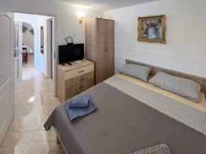 a bedroom with a large bed and a television at Holiday Home Aurora - Three bedroom Holiday Home in Splitska