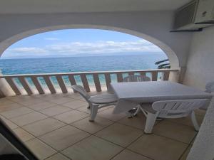 Una mesa y sillas en un balcón con vista al mar. en Apartments Pansion Franka 4 - Apt 7, en Brist