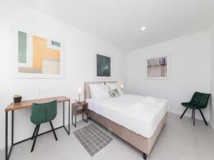 ein weißes Schlafzimmer mit einem Bett und einem Schreibtisch in der Unterkunft Luxury Villas Bellavista - Four Bedroom Villa with Pool in Pag + 25 Fotos