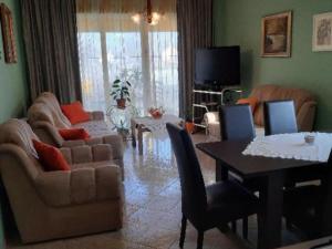 a living room with a couch and a table with chairs at One Bedroom Apartment with Balcony in Gajić