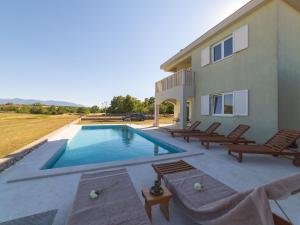 a swimming pool with chairs and a house at Idyllic Getaway Lovrec Villa with Pool - Five Bedroom Villa with Pool in Lovreć