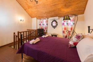 a bedroom with a purple bed and a wooden ceiling at The old town Neighbourhood in Rhodes Town