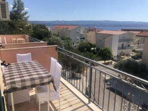a table and chairs on a balcony with a view at Apartmani Villa Borzic - One Bedroom Apartment with Terarce and Sea View in Omiš