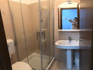 a woman taking a picture of a bathroom with a shower at Chic and Cozy Brsec Apartment with Sea View - Two Bedroom Apartment with Sea View in Brseč
