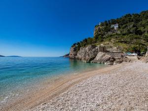 a beach with a rocky shore and the ocean at Chic and Cozy Brsec Apartment with Sea View - Two Bedroom Apartment with Sea View in Brseč