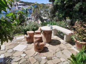 un patio en pierre avec une table et trois rondins dans l'établissement Guest House Green Corner Supetarska Draga - Studio Apartment with Terrace And Sea View, à Rab 13 autres photos