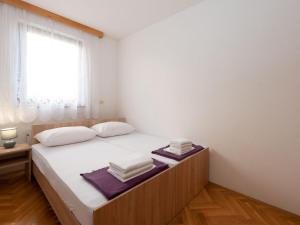 a bedroom with a bed with white sheets and a window at Cozy Icici Apartment with Sea view - Two Bedroom Apartment with Sea View in Ičići