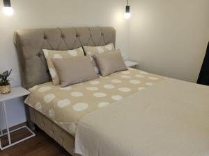 a bedroom with a large bed with polka dot pillows at Vlla Magnolia Pirovac in Pirovac