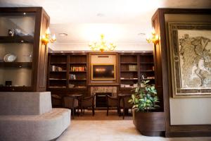 - une bibliothèque avec une télévision, une table et des chaises dans l'établissement Hotel Barbieri, à Altomonte