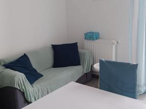 a couch with blue pillows in a living room at FreeMe Apartment - One Bedroom Apartment with Balcony and Sea View in Lumbarda