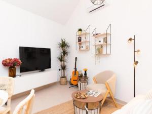 ein weißes Wohnzimmer mit einem Flachbild-TV an der Wand in der Unterkunft Villa ADRIANA - Two bedroom Villa with swimming pool in Nerežišće