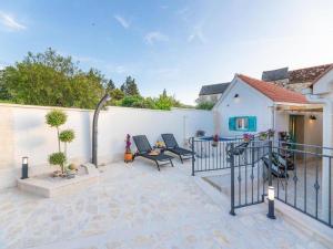 eine Terrasse mit 2 Stühlen und einem Zaun in der Unterkunft Villa ADRIANA - Two bedroom Villa with swimming pool in Nerežišće