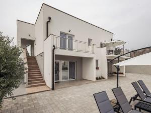 a white house with chairs and a staircase at Holiday Home Milutin 1 - Four Bedroom Holiday Home with Private Pool in Vrsi