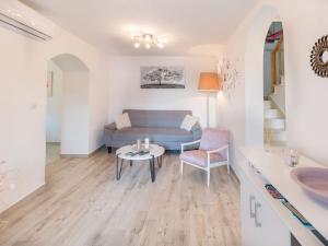 a living room with a blue couch and a table at Four Bedroom Holiday Home with Sea View in Ston