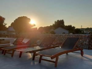 a group of benches sitting on top of a roof at Villa Tamaris - Two Bedroom Holiday Home with Terrace and Swimming pool in Mali Drvenik
