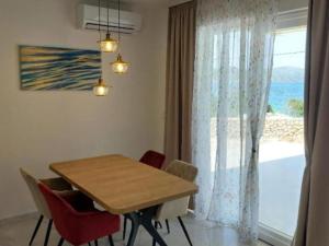 a dining room with a table and a large window at Villa Tamaris - Two Bedroom Holiday Home with Terrace and Swimming pool in Mali Drvenik