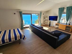 a bedroom with a couch and a bed and a television at Holiday Home Sunrise - Three Bedroom Holiday Home in Omiš