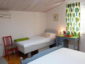 a bedroom with two beds and a desk and a chair at Apartment Juri i Kor ula - One Bedroom Apartment with Terrace in Korčula
