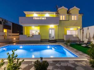 a swimming pool in front of a house at Villa Ava - Five Bedroom Villa with Swimming pool in Šibenik