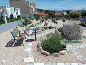 a patio with a bench and a table and plants at Villa Ava - Five Bedroom Villa with Swimming pool in Šibenik