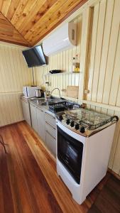 a kitchen with a stove top oven in a room at Casa Encantos da Serra em Canela in Canela +11 photos