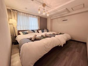 two large beds in a bedroom with a window at Hotel GRACIAS KOBE in Kobe
