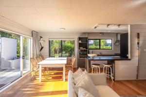 eine Küche und ein Wohnzimmer mit Tisch und Stühlen in der Unterkunft Viletta Hauraki by Waiheke Pure in Waiheke Island