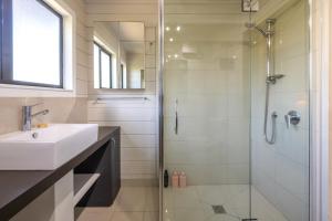 ein Badezimmer mit Waschbecken und Dusche in der Unterkunft Viletta Hauraki by Waiheke Pure in Waiheke Island + 29 Fotos