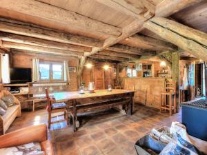 un soggiorno con un tavolo di legno e un divano di Chalet savoyard, 4 chambres, sauna et jacuzzi à St-Gervais - FR-1-663-42 a Saint-Gervais-les-Bains