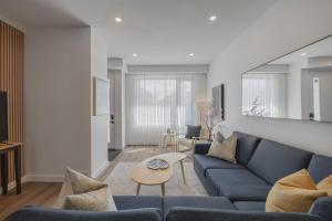 ein Wohnzimmer mit einem blauen Sofa und einem Tisch in der Unterkunft Fenced Yard, Free Parking, 2 King Beds with AC in Calgary