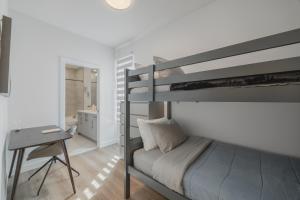 ein Schlafzimmer mit Etagenbett und Schreibtisch in der Unterkunft Fenced Yard, Free Parking, 2 King Beds with AC in Calgary