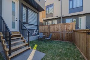 ein kleiner Hinterhof mit einem Holzzaun und einer Treppe in der Unterkunft Fenced Yard, Free Parking, 2 King Beds with AC in Calgary