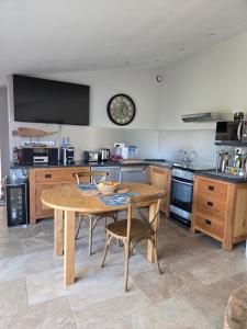 a kitchen with a wooden table and a clock on the wall at hammam et jacuzzi en Provence in Caphan