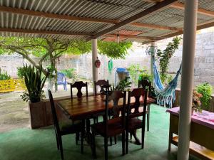 a dining room table and chairs under a pergola at Casa aconchegante em Barra de Caravelas in Caravelas