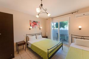 a bedroom with a bed and a balcony at Kipos Resort in Nea Peramos