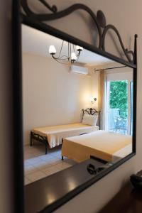 a reflection of a bedroom with two beds in a mirror at Kipos Resort in Nea Peramos